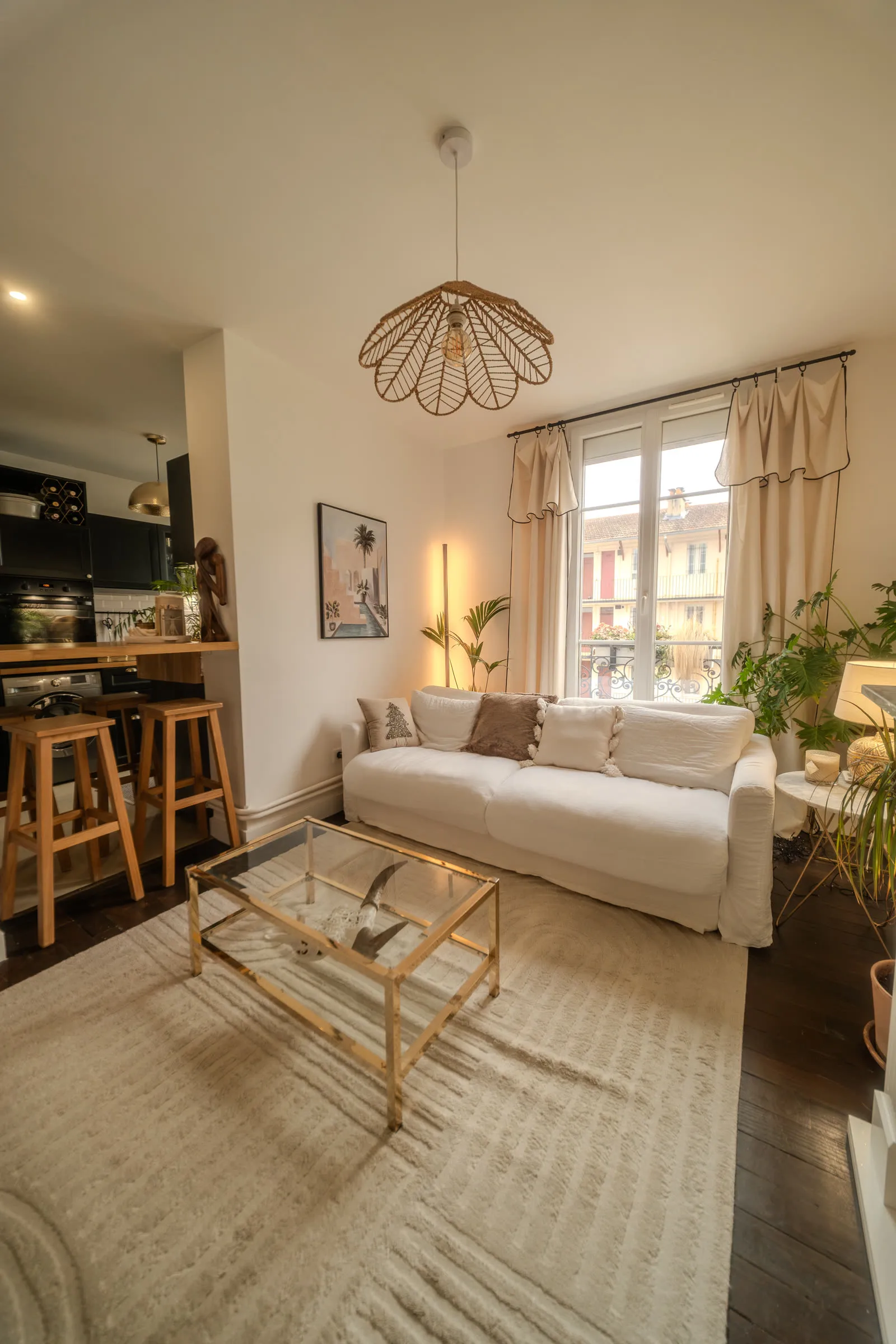 Salon lumineux de l'appartement parisien — canapé blanc, table basse dorée.